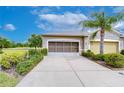 Exterior shot of a two car garage with a paved driveaway and manicured landscaping at 2401 Richmond Greens Ct, Sun City Center, FL 33573