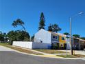 Corner lot townhouse featuring a white fence, colorful facade, and a clear view of the neighborhood at 2930 S Pines Dr # 109, Largo, FL 33771