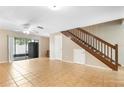 Bright living room with tile flooring, ceiling fan, and wooden staircase leading to the second floor at 2930 S Pines Dr # 109, Largo, FL 33771