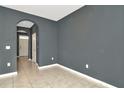 Open living room with tile floors, an archway, and gray walls at 2949 Suncoast Plains Dr, Odessa, FL 33556