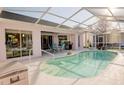View of the screened-in pool, outdoor seating, and access to the home's interior at 3051 Jodi Ln, Palm Harbor, FL 34684