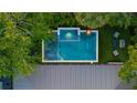 Aerial view of backyard pool and jacuzzi surrounded by lush, tropical landscaping and elegant outdoor furniture at 3105 S Schiller St, Tampa, FL 33629
