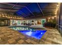 Inviting screened-in pool area featuring a large pool, comfortable patio furniture, and ambient string lights at 3612 Sugar Loaf Ln, Valrico, FL 33596