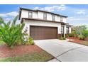 Charming two-story home with a large driveway and well-maintained lawn and lush landscaping at 5424 Hammock View Ln, Apollo Beach, FL 33572
