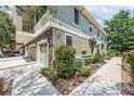 Corner view of a two story home featuring stone accents, and a three car garage with landscaped yard at 5714 Kingletsound Pl, Lithia, FL 33547