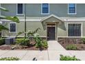 Front entrance of a two story home featuring a black door, manicured landscaping, and neutral colors at 5714 Kingletsound Pl, Lithia, FL 33547