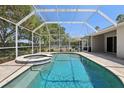 Enjoy a refreshing swim in this screened-in pool with an attached hot tub, perfect for outdoor relaxation at 8847 Bel Meadow Way, Trinity, FL 34655
