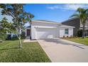 Well-manicured, one-story home with a two-car garage and a driveway, with an easy to maintain front lawn at 1506 Climbing Dayflower Dr, Ruskin, FL 33570