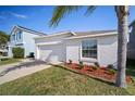 Well-manicured, one-story home with a two-car garage and a driveway, with an easy to maintain front lawn at 1506 Climbing Dayflower Dr, Ruskin, FL 33570