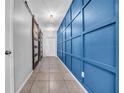 Hallway with a decorative blue accent wall and sliding barn door at 10612 Strawberry Tetra Dr, Riverview, FL 33578