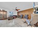 Spacious living room with tile flooring, wood paneled wall, ceiling fan, and comfortable seating at 10612 Strawberry Tetra Dr, Riverview, FL 33578