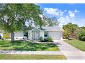Charming single-story home with light blue accents, landscaped front yard, and a paved driveway at 10790 92Nd St, Seminole, FL 33777