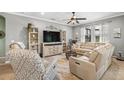 Inviting living room with comfortable seating, a ceiling fan, and plenty of natural light at 11327 Emerald Shore Dr, Riverview, FL 33579