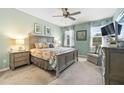 Comfortable main bedroom featuring a ceiling fan, a large bed, and natural light at 11327 Emerald Shore Dr, Riverview, FL 33579