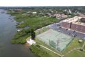 Overhead view of a waterfront tennis court adjacent to condo complex and lush greenery along the waterway at 12760 Indian Rocks Rd # 579, Largo, FL 33774