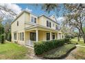 Side view of a two-story yellow home showcasing its architectural design and well-maintained landscaping at 16113 Ternglade Dr, Lithia, FL 33547