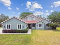 Inviting home with lush green lawn, neatly trimmed bushes, and striking red tile roof at 18502 Keystone Manor Rd, Odessa, FL 33556