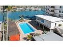 Waterfront community pool with lounge chairs, docks, and beautiful water views at 223 Island Way # 2C, Clearwater Beach, FL 33767