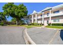 Low angle view of a multi-Gathering, two story building with white paint, multiple balconies and parking on the left at 2291 Americus W Blvd # 23, Clearwater, FL 33763