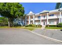Low angle view of a multi-Gathering, two story building with white paint, multiple balconies and parking at 2291 Americus W Blvd # 23, Clearwater, FL 33763