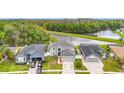 An aerial view displays this waterfront home surrounded by lush trees and a serene lake at 25029 Hyde Park Blvd, Land O Lakes, FL 34639
