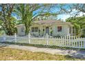Inviting single-story home with a well-maintained lawn and charming white picket fence enhances the property's appeal at 2708 5Th S St, St Petersburg, FL 33705