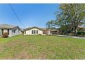 Single-story home featuring a spacious lawn, complemented by mature trees and a two-car garage at 3334 Pineview Dr, Holiday, FL 34691