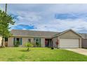 Inviting single-story home featuring lush green lawn, an attached garage, and charming turquoise shutters and front door at 3410 5Th W Dr, Palmetto, FL 34221