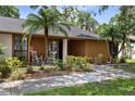 Close up of the front porch with seating and tropical landscaping at 4715 Kemble Ct, Tampa, FL 33624