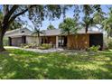 Inviting single-story home with manicured front yard, lovely landscaping, and a covered entrance with rocking chairs at 4715 Kemble Ct, Tampa, FL 33624