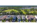 Aerial view of homes in a beautiful community with scenic green spaces, a pond, and lush landscaping at 5415 Los Robles Ct, Palmetto, FL 34221