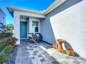 Inviting front porch with seating, a vibrant blue door, beautiful stone pavers and colorful plants at 5415 Los Robles Ct, Palmetto, FL 34221