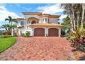 Charming two-story home with a brick driveway and lush greenery, showcasing curb appeal at 5630 Bayview Dr, Seminole, FL 33772