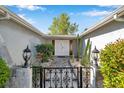 Welcoming front entrance with a decorative gate, manicured bushes, and elegant lighting at 7824 Blackstone Dr, Port Richey, FL 34668