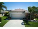 Exterior angle of a single-Gathering home with lush landscaping and a two-car garage at 9736 Sage Creek Dr, Ruskin, FL 33573