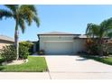 Front exterior of home with well-maintained landscaping, complemented by a lush lawn at 9736 Sage Creek Dr, Ruskin, FL 33573