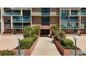 Building E entrance with palm trees and manicured landscaping leading to the doors in a condo community in Florida at 1 Key Capri # 301E, Treasure Island, FL 33706