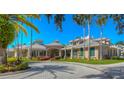 Exterior of a clubhouse featuring manicured lawns and palm trees at 10144 Arbor Run Dr # 122, Tampa, FL 33647
