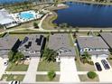 A house with solar panels is showcased in an aerial view alongside nearby community amenities and houses at 11416 Carlton Fields Dr, Riverview, FL 33579