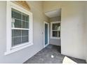 Covered front porch with brick pavers and neutral paint, offering a shaded entry to the home at 12408 Palatka Dr, Venice, FL 34293