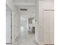 Bright hallway featuring neutral tones and tile floors, leading to the kitchen and living spaces at 12408 Palatka Dr, Venice, FL 34293