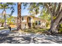 Charming exterior view of tan home, with mature trees, arched entry and two car garage at 14323 83Rd Pl, Seminole, FL 33776