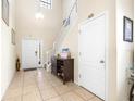Bright foyer with high ceilings, tile flooring, a staircase, and a white front door at 1564 Imperial Key Dr, Trinity, FL 34655