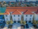 Waterfront townhouse featuring a red tile roof, white facade, and stunning views of the bay at 161 Brightwater Dr # 8, Clearwater Beach, FL 33767