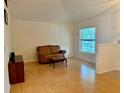 Bright living room features wood flooring, a large window, and a comfortable seating area at 224 Chardonnay Pl, Valrico, FL 33594