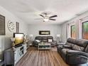 Comfortable living room with a modern fireplace, ceiling fan, and stylish furnishings at 2644 2Nd Ct, Palm Harbor, FL 34684