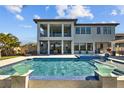 Luxury home's outdoor space featuring a large pool, spa, covered patio, and lounge seating at 28355 Picana, Wesley Chapel, FL 33543