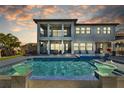 Luxury home's outdoor space featuring a large pool, spa, covered patio, and lounge seating at 28355 Picana, Wesley Chapel, FL 33543