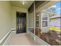 Front porch with neutral finishes and a view of the landscaped garden bed in the front yard at 29250 Princeville Dr, San Antonio, FL 33576