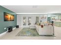 Inviting living room featuring a modern sofa, a unique rug, and views into the kitchen at 320 Lake Maggiore S Blvd, St Petersburg, FL 33705